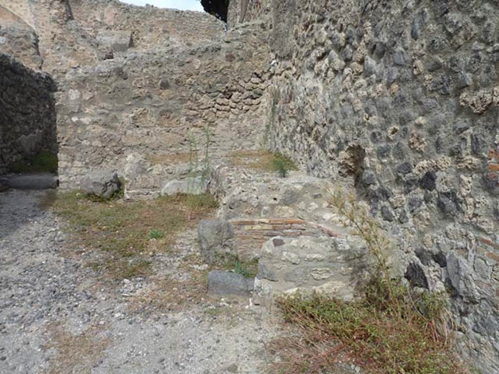 VIII.4.35 Pompeii, September 2015. North-east corner of shop. Remains of two-sided podium or counter with a furnace and tub.