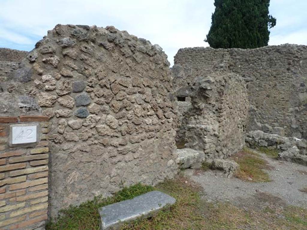 VIII.4.42 Pompeii. September 2015. North wall, with a doorway linking to VIII.4.43.
According to Fiorelli,  VIII.4.42 –Segue un stabulum, che rinchiude la mangiatoia, l’abbeveratoio, e la stalla: innanzi al suo ingress furono svelte dal margine della via i sassi che lo contornavano, per dare piu commodo accesso agli animali. (translation: “Following was a stable, which had a feeding and water trough and the stall: also at its entrance was a more commodious entrance for the animals”.
VIII.4.43 – Vi era di fianco una cella pel custos stabuli, che guardava in esso, e communicava con la bottega attigua. (translation: “At the side was a room for the custos stabuli, which communicated with the adjoining shop”.)
See Pappalardo, U., 2001. La Descrizione di Pompei per Giuseppe Fiorelli (1875). Napoli: Massa Editore. (p.130).