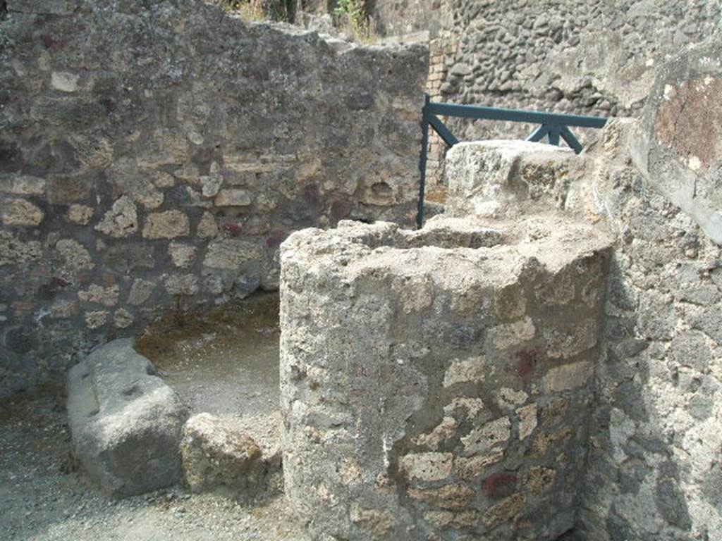 VIII.5.1 Pompeii. South-west corner of shop, with doorway to VIII.5.40.
Also seen is a large brick cylindrical tank. See Eschebach, L., 1993. Gebäudeverzeichnis und Stadtplan der antiken Stadt Pompeji. Köln: Böhlau. (p.379)