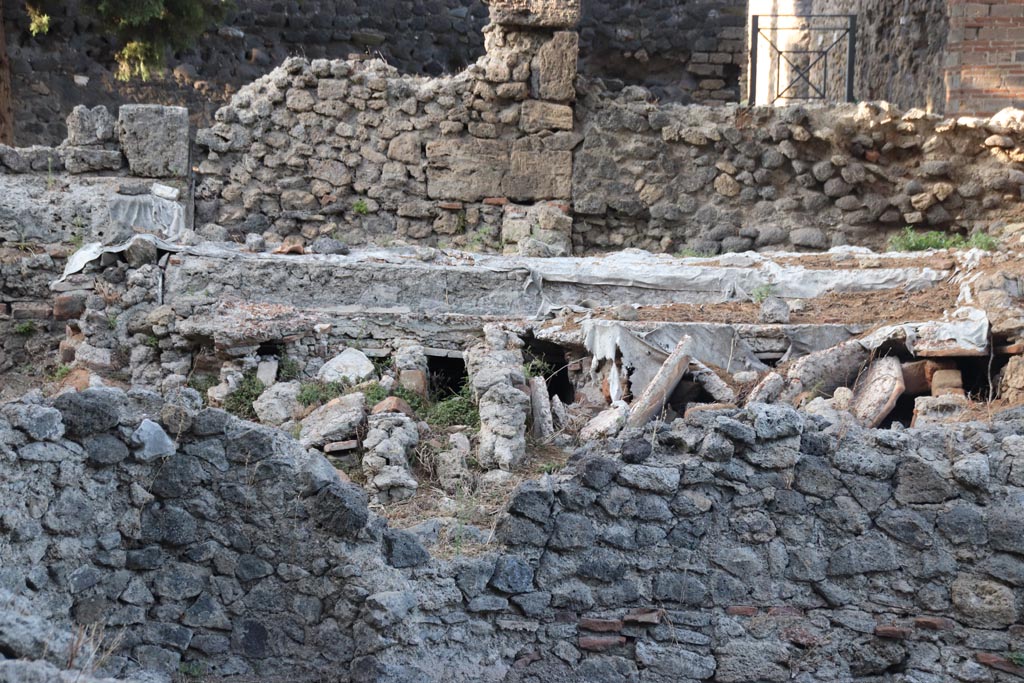 VIII.5.36 Pompeii. October 2023. 
Looking north from Vicolo delle Pareti Rosse, detail of suspensurae under flooring. Photo courtesy of Klaus Heese.