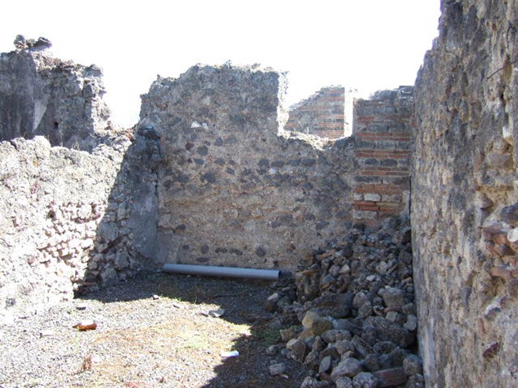 VIII.6.11 Pompeii. September 2005.  Room on south side of entrance, according to Eschebach – a stable?. See Eschebach, L., 1993. Gebäudeverzeichnis und Stadtplan der antiken Stadt Pompeji. Köln: Böhlau. (p.386)
According to Mau, the use of room “f” was unknown. It was found without any other decoration than a zoccolo as in room “e” (made of a reddish stucco made by the addition of brick dust), and had a separate entrance from the western roadway. On entering the doorway from the roadway, on the right was a staircase (two stone steps, the reminder made of wood) to the upper floor. On the left was the toilet, from which in order to reach “f”, you had to go down 0.60m. See BdI, 1884, p.139
(È ignota del pari la destinazione di “f”, senz'altra decorazione che uno zoccolo come quello di “e”; ha un ingresso separato dal vico occidentale, entrando per il quale si aveva a destra una scala (due gradini di pietra, il resto di legno) per località superiori, a sinistra il cesso, mentre per giungere in “f” bisogna scendere m. 0,60. Un'altra scala stava addosso alla parete verso il pistrino, e doveva passare sopra la porta e avanti ad un angolo di essa.)