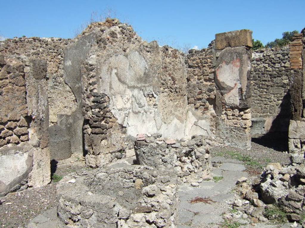 VIII.6.11 Pompeii. September 2005. Looking east towards north-east corner of bakery, and doorway to “room e”, on right. According to Mau, room "e" was a room without other decoration than a zoccolo of reddish stucco made with the addition of brick dust. Here, in the places marked on the plan, are two millstones, and over each of them was a low clay basin, which holds another of similar form of lead (diam. 1 m.); each of the two clay basins had a stamp mark, (see BdI for copy of mark). In the right wall which is devoid of plaster, you could see the holes of the supports for a shelf: in the rear wall, where the plaster is conserved, these holes have been closed in the past. See BdI, 1884, p.139
(“e” è una camera senz' altra decorazione che uno zoccolo di stucco rossastro per l'aggiunta di polvere di mattoni ; qui stanno, nei posti segnati sulla pianta, due macine, e sopra ognuna di esse un basso bacile di creta, che ne sorregge un altro di forma simile di piombo (diam. m. 1); ognuno dei due bacili di creta porta il bollo, (vedi p.139 BdI) Nel muro destra, che è privo d'intonaco, si vedono i buchi dei mutuli per una scansia ; nel muro di fondo, ov'è conservato l'intonaco, tali buchi sono stati chiusi anticamente.)