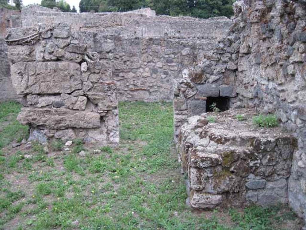 VIII.7.6 Pompeii. September 2010. Photo courtesy of Drew Baker.
Looking east from atrium of VIII.7.6, doorway in south-east corner leading to room in VIII.7.5.  According to Fiorelli, in the atrium area was found a hearth and oven in proximity of the workshop, to service its feeding needs.
See Pappalardo, U., 2001. La Descrizione di Pompei per Giuseppe Fiorelli (1875). Napoli: Massa Editore. (p.131)