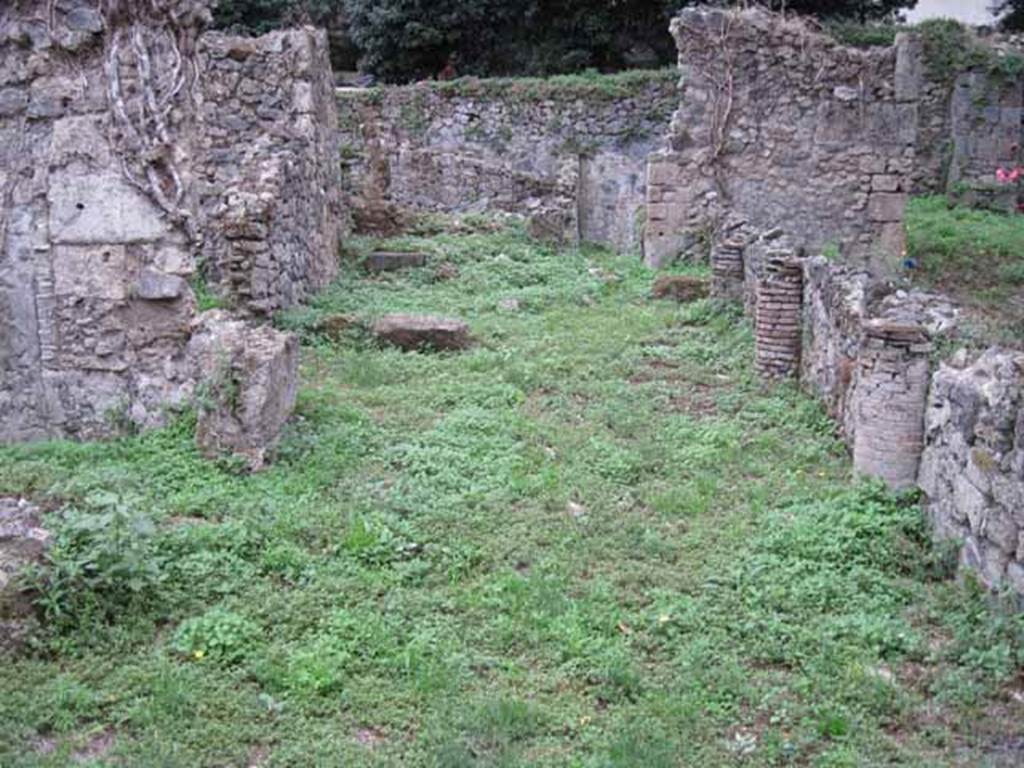 VIII.7.6 Pompeii. September 2010.  Photo courtesy of Drew Baker.
Rear area portico looking south towards city wall, the triclinium is on the right behind the wall).
According to Jashemski, the four columns supporting the portico were black below and white above. They were connected  by a low wall and the entrance to the garden was at the north end.