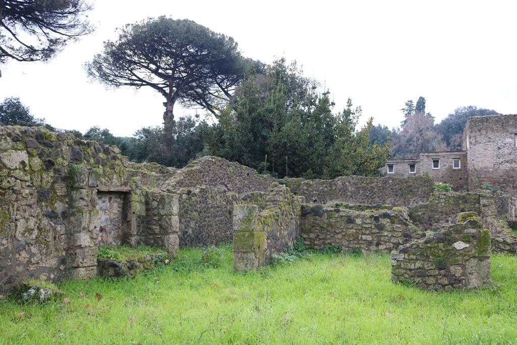 VIII.7.8 Pompeii. December 2018. 
Looking south-west from entrance doorway, towards south wall with kitchen/bench and corridor to rear, on left. Photo courtesy of Aude Durand.
According to Mau –
“In the north-west corner of the large room, there was the remains of a brick column, in the south-west corner there was a mass of masonry in the form of a bench or a low table, and at the foot of it towards the east were two round basins (diam. c.0.42), however of a not entirely regular shape, one of which widens in the lower part.”
See Mau in BdI, 1875, (p. 165 – Terza casa).