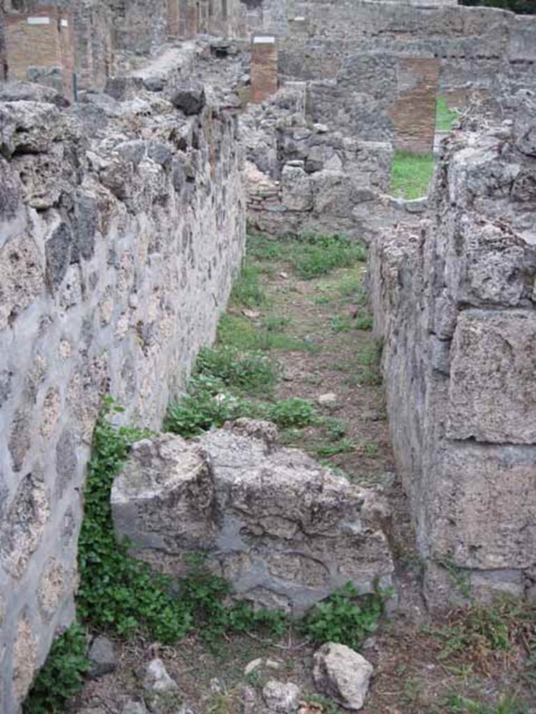 VIII.7.10 Pompeii. September 2010.  Corridor looking east towards road (low wall block in foreground). This would seem to have been taken from the kitchen, but presumably was not blocked in antiquity ?