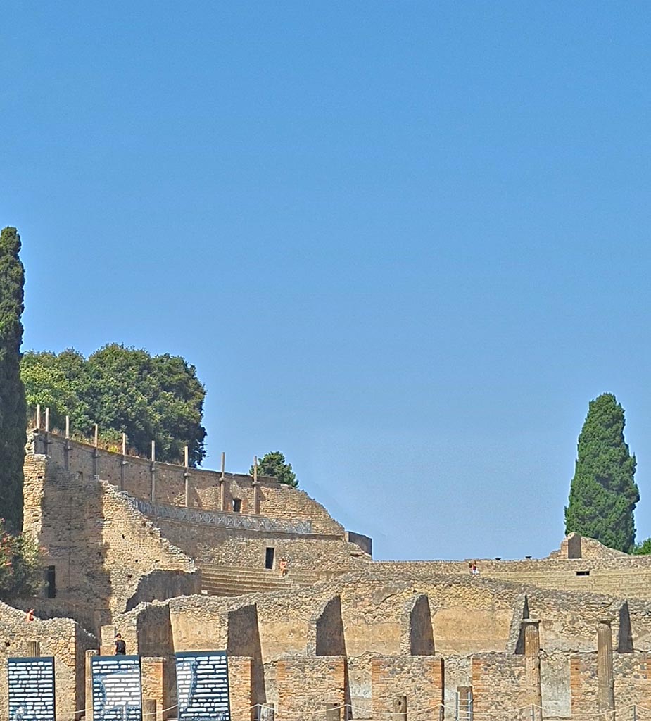 VIII.7.16 Pompeii. September 2024. 
Looking north-west to upper level of Large Theatre, from Gladiator’s Barracks. Photo courtesy of Giuseppe Ciaramella.