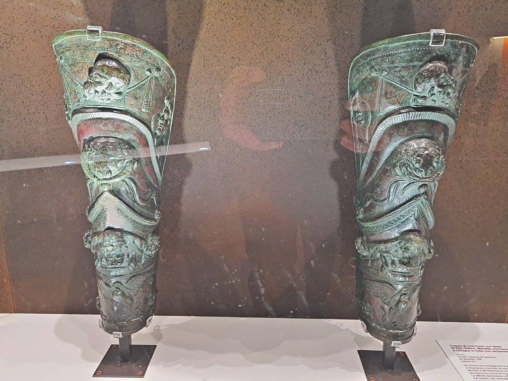 VIII.7.16 Pompeii. Pair of richly decorated greaves each depicting a procession in celebration of Bacchus, Silenus with masks of the god and a lion skin, and a stork fighting a snake. 
Photo taken May 2021, courtesy of Giuseppe Ciaramella.