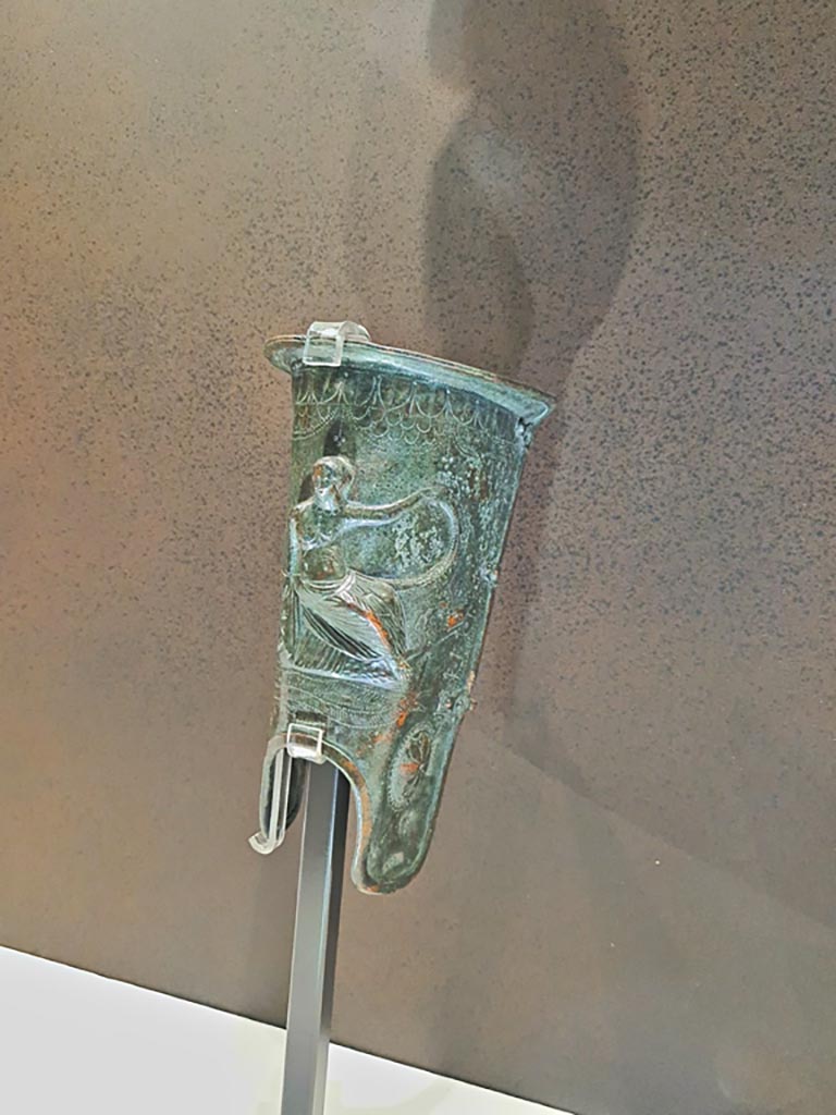 VIII.7.16 Pompeii. 
Bronze greave with Aphrodite Euploia (protector of seafarers) sitting on a ship’s prow, inv. 5675. Found 20th December 1766.
Photo taken May 2021, courtesy of Giuseppe Ciaramella.