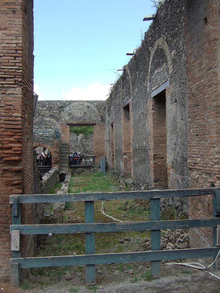 VIII.7.18 Pompeii. May 2006. Site of stage, looking east.
Looking east towards entrance from corridor, along site of stage, towards Tribunal over arched entrance.
