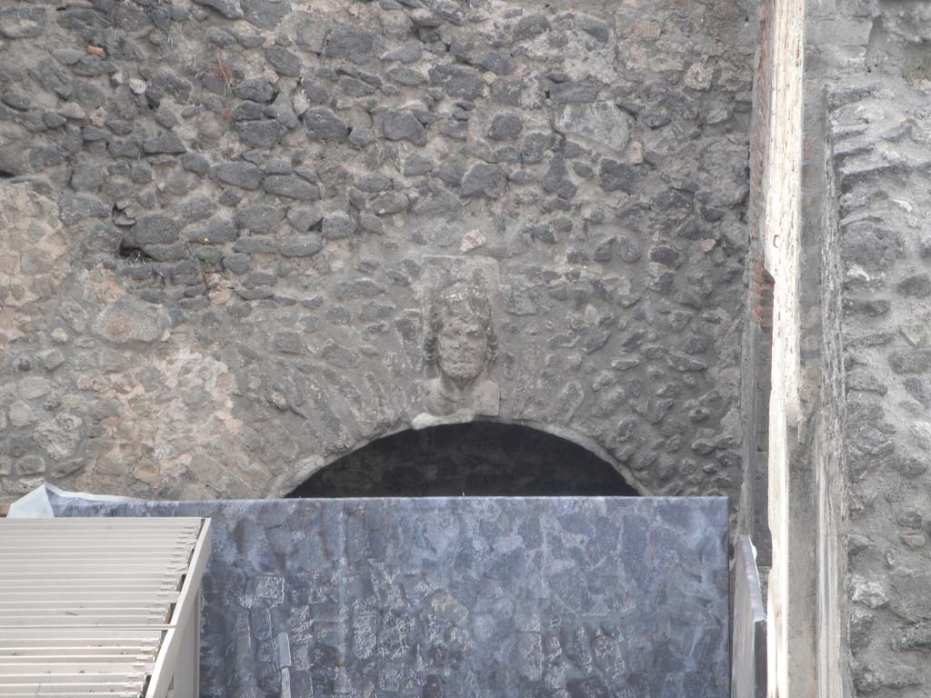 VIII.7.20 Pompeii. May 2011. 
West side, during renovation work. Head of Bacchus over entrance to room under the seating. Photo courtesy of Ivo van der Graaff.