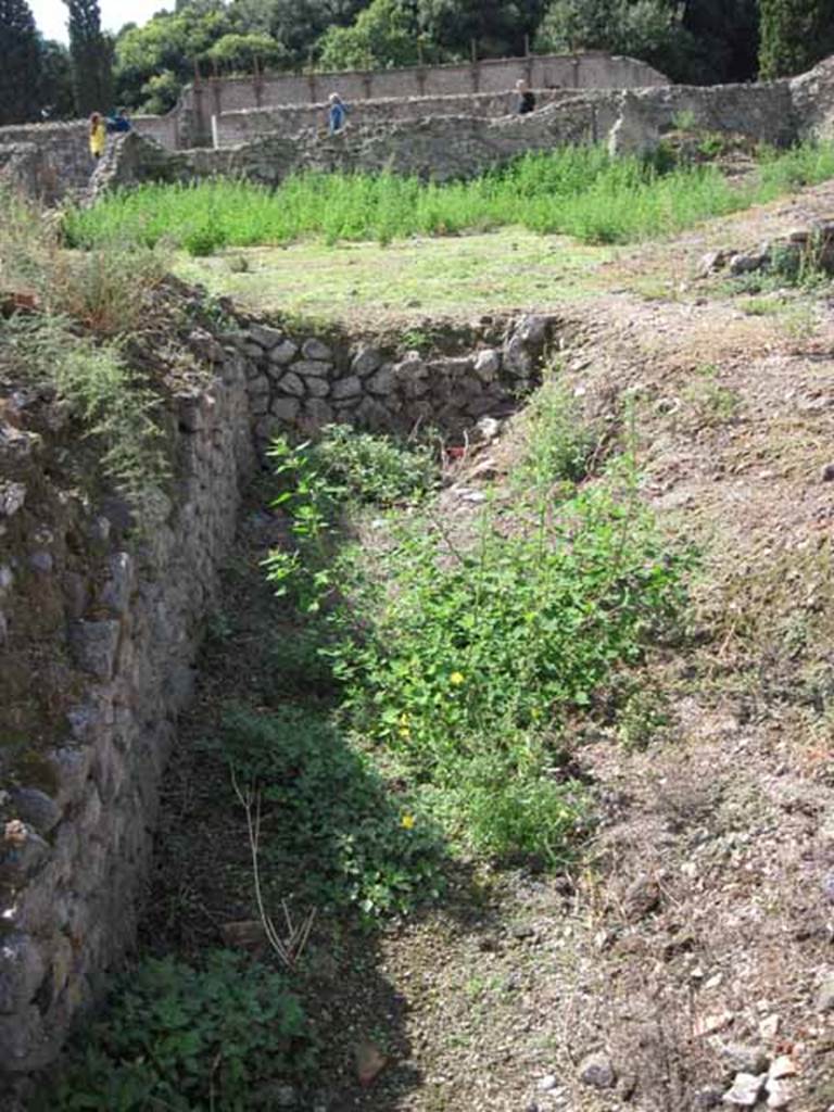 VIII.7.24 Pompeii. September 2010.  South-west corner of south portico of garden area.  Also looking west towards upper level of theatre across garden of VIII.7.26. Photo courtesy of Drew Baker.