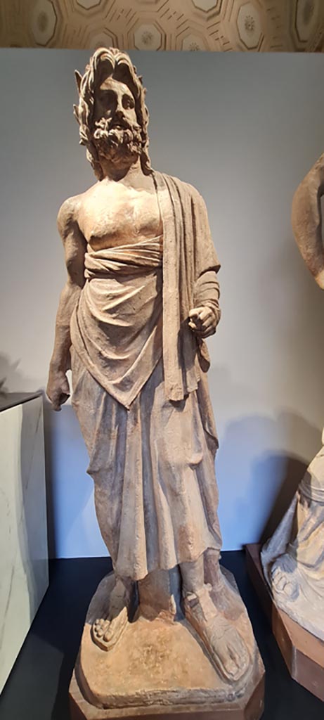 VIII.7.25 Pompeii. April 2023.
Terracotta statue of Aesculapius or Asclepius the god of medicine and healing, found in the cella.
According to the information card in Naples Museum –
the god is shown wrapped in a thick cloak, and wears a wreath made of bay laurel, the tree sacred to his father Apollo.
Photo courtesy of Giuseppe Ciaramella.
.