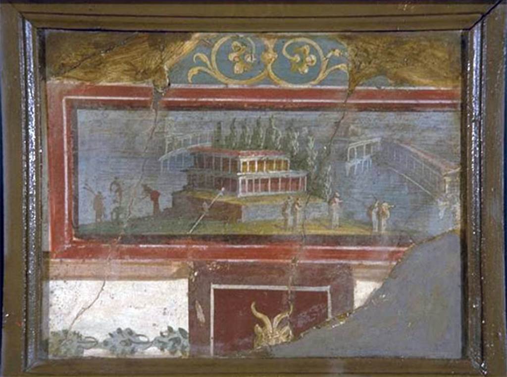 VIII.7.28 Pompeii. On 1st March 1766, three fragments were found on the ground at the west end of the north portico. 
According to P.P.M., these were reassembled to form a square on the upper part of the western section of the north wall. 
In addition to the picture with landscape also preserved is part of the decorative context in which it was inserted. 
The picture shows in the foreground a small island on which there is a building with two storeys of porticoes erected on a high podium and closed at the back by a row of cypress trees. 
On the right, toward the shore, there are five cloaked figures and two other on the left, next to an ithyphallic statue. In the background are some arcaded buildings on stilts. 
At the top of the fresco, resting on the picture frame, is a pediment with scrolls. 
Below the picture frame is a dark red panel with the head of a goat. 
To the side of the red panel is a tight garland on a white background. 
The remarkable freshness of the colours and the legibility of the picture were probably the reasons that led the excavators to recover the three fragments.
Now in Naples Archaeological Museum. Inventory number 9490.
See Carratelli, G. P., 1990-2003. Pompei: Pitture e Mosaici: Vol. VIII. Roma: Istituto della enciclopedia italiana, p. 742.
