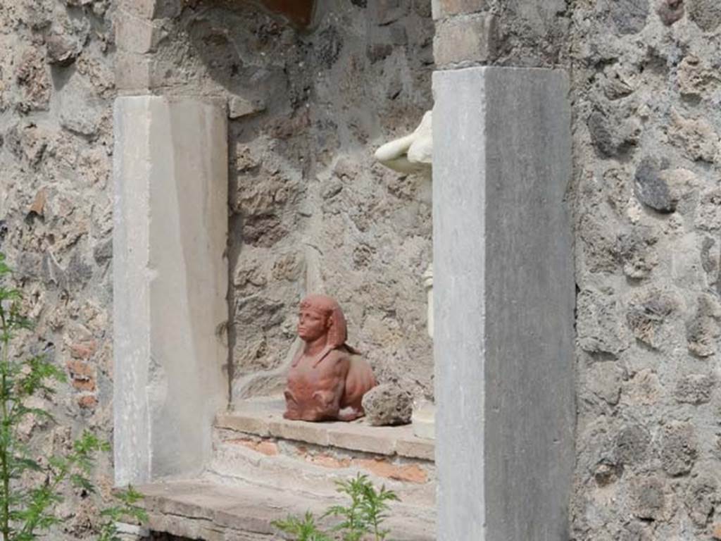 VIII.7.28 Pompeii. May 2017. Niche with reproduction pottery sphinx in north-west corner of the sacred room or Hall of initiation. 
Now in Naples Archaeological Museum. Inventory number 22572.
Also in the niche is a reproduction marble statue of Venus Anadyomene (Venus drying her hair after a bath). 
Found against the west wall of the portico in the south west corner.
Now in Naples Archaeological Museum. Inventory number 6298.
Photo courtesy of Buzz Ferebee.