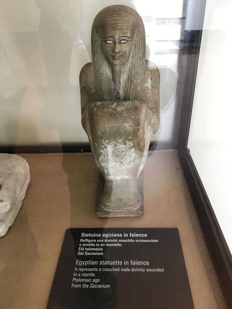 VIII.7.28 Pompeii. April 2019. Ptolemaic era. Found in the niche on the north wall of the sacrarium.
Egyptian statue in faience representing a crouched male divinity covered in a mantle.
Now in Naples Archaeological Museum. Inventory number 430. Photo courtesy of Rick Bauer.