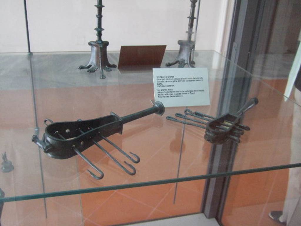 VIII.7.28 Pompeii.   Bronze sistra (rattles) found in the Ekklesiasterion and decorated with the head of a sacred cat.Now in Naples Archaeological Museum.