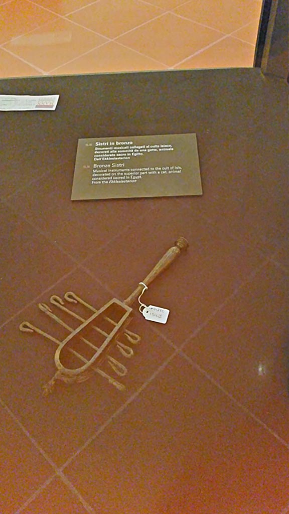 VIII.7.28 Pompeii. 2016/2017.
According to the information card –
“Bronze Sistri – musical instruments connected to the cult of Isis decorated on the superior part with a cat animal considered sacred in Egypt.
Found in the Ekklesiasterion.”
Photo courtesy of Giuseppe Ciaramella.