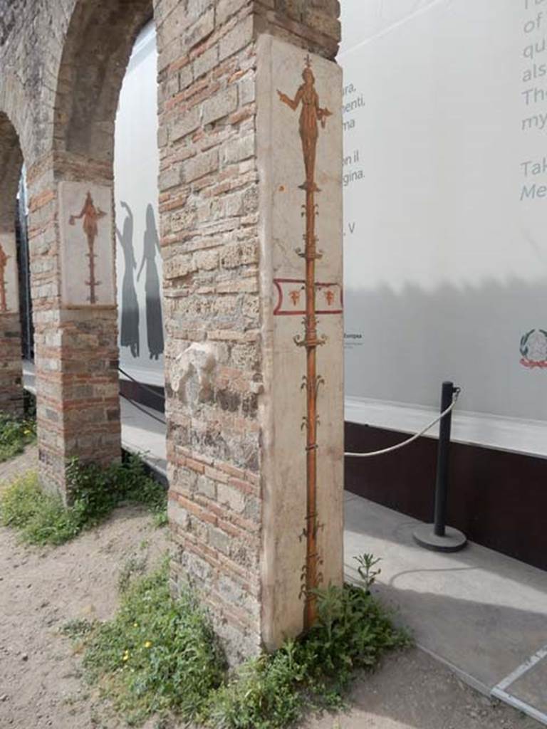 VIII.7.28 Pompeii. May 2017. Reproduction candelabra frescoes on arches in the Ekklesiasterion.
The longer fresco is on the south wall of the first arch from the north and shows a priestess, on the top of a candelabrum, carrying a small crocodile in her right hand, and a tray and vase in her left.  
Now in Naples Archaeological Museum. Inventory number 9768.
The shorter fresco is on the south wall of the second arch from the north and shows a priestess, on the top of a candelabrum, holding a cobra and jar.
Now in Naples Archaeological Museum. Inventory number 8928.
Photo courtesy of Buzz Ferebee.