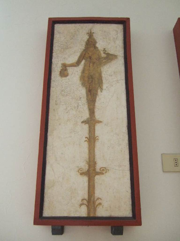 VIII.7.28 Pompeii.  Priestess on a candelabrum with jar and peacock. Found in passageway of arch.  Now in Naples Archaeological Museum.