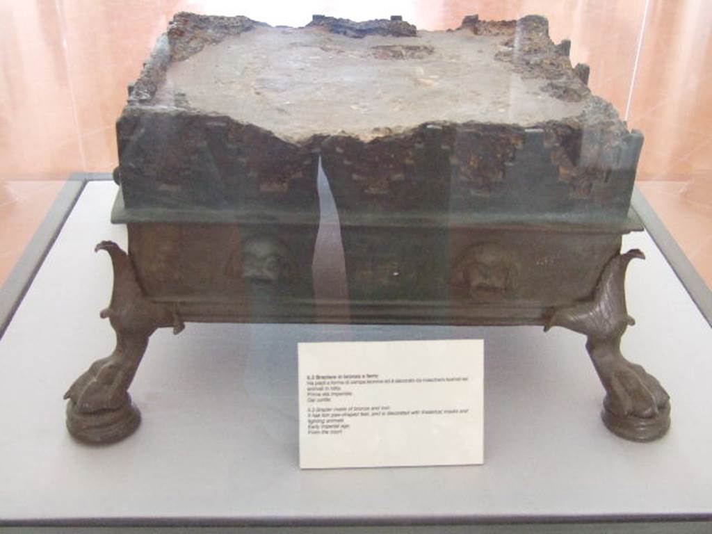VIII.7.28 Pompeii. Found in the court of the temple. 
Brazier made of bronze and iron with lion’s paw feet and decorated with theatrical masks and animals fighting. 
Now in Naples Archaeological Museum. Inventory number 135.