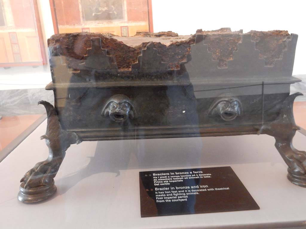 VIII.7.28 Pompeii. Found in the court of the temple. 
Detail of Brazier made of bronze and iron with lion’s paw feet and decorated with theatrical masks and animals fighting. 
Now in Naples Archaeological Museum. Inventory number 135. Photo courtesy of Buzz Ferebee.