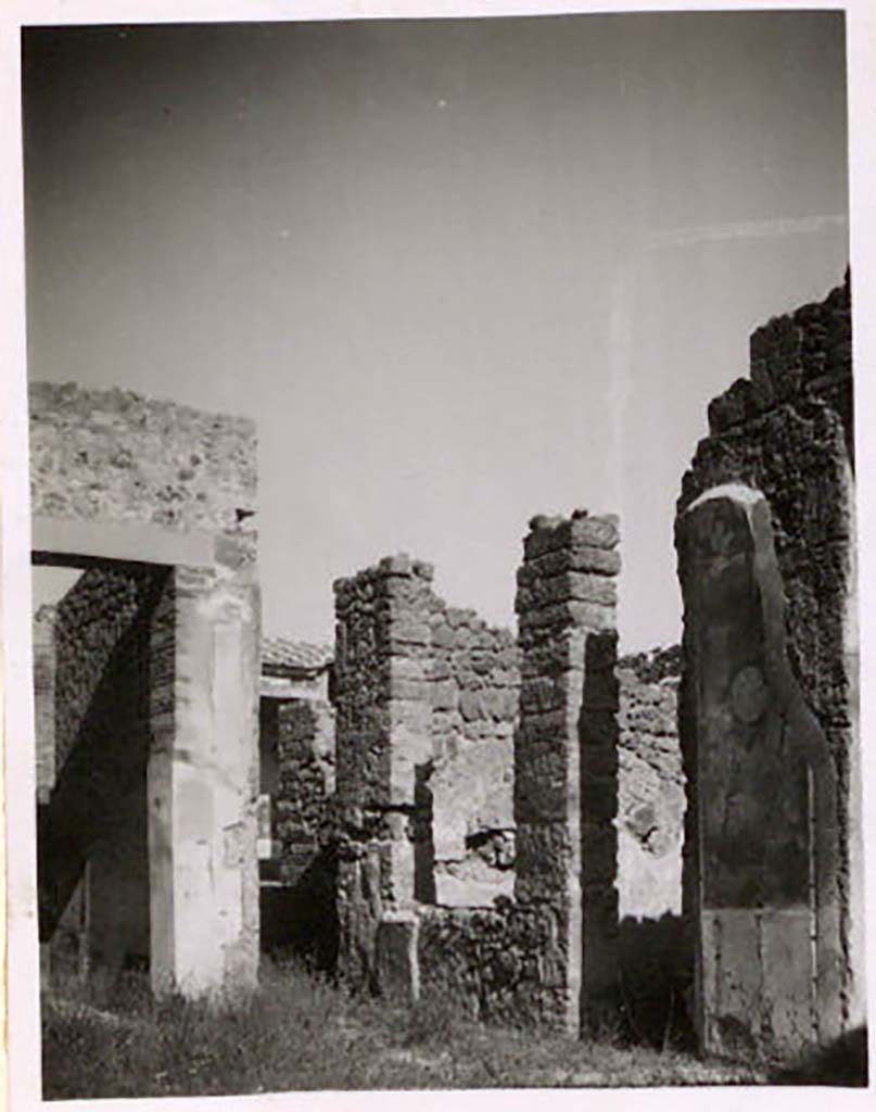 IX.1.22 Pompeii. Pre-1943. Room 1, looking towards room 6, on east side of atrium. Photo by Tatiana Warscher.
According to Warscher – “the wall decoration was the same as the west wall. 
On the wall (in the photo above) one can clearly see a medallion, and at the other end of the same wall, near the lararium, one can clearly see a rectangle.”
See Warscher, T. Codex Topographicus Pompeianus, IX.1. (1943), Swedish Institute, Rome. (no.114), p. 199.
