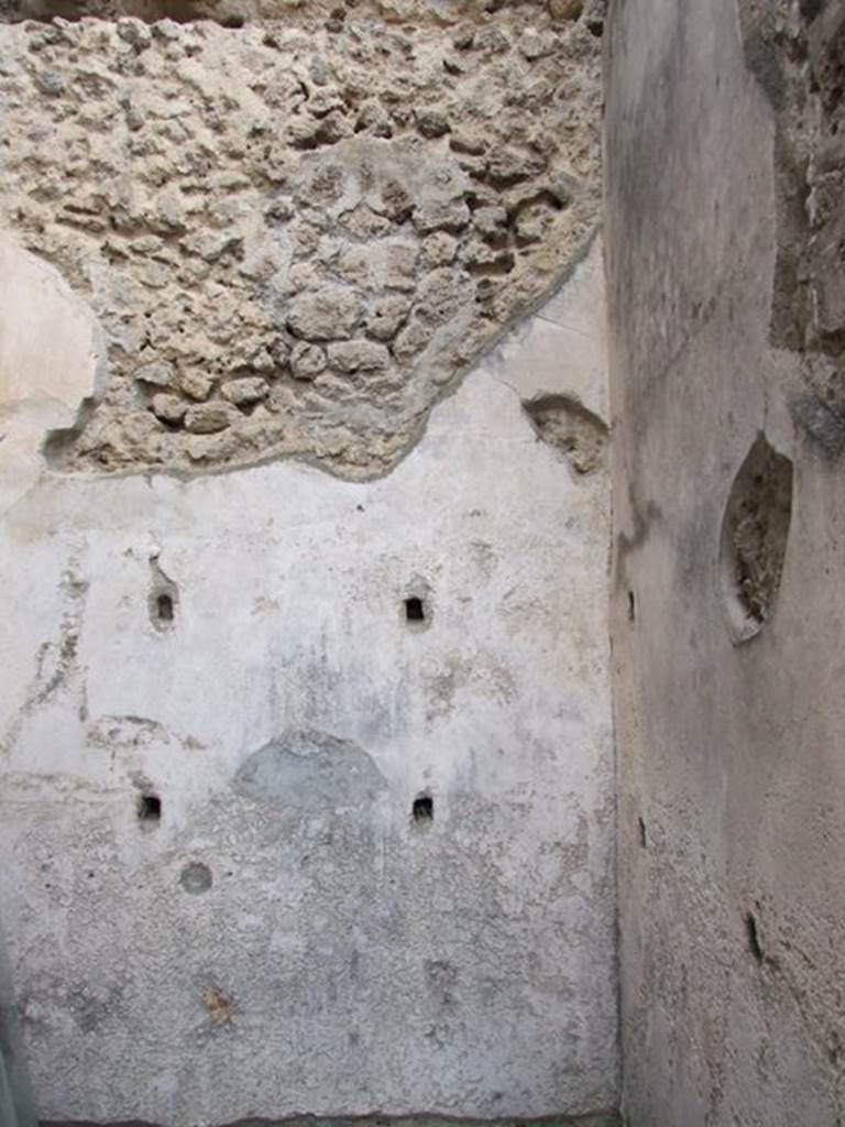 IX.1.22 Pompeii. December 2007. Room 8, white painted plaster on north wall with holes for shelving supports.