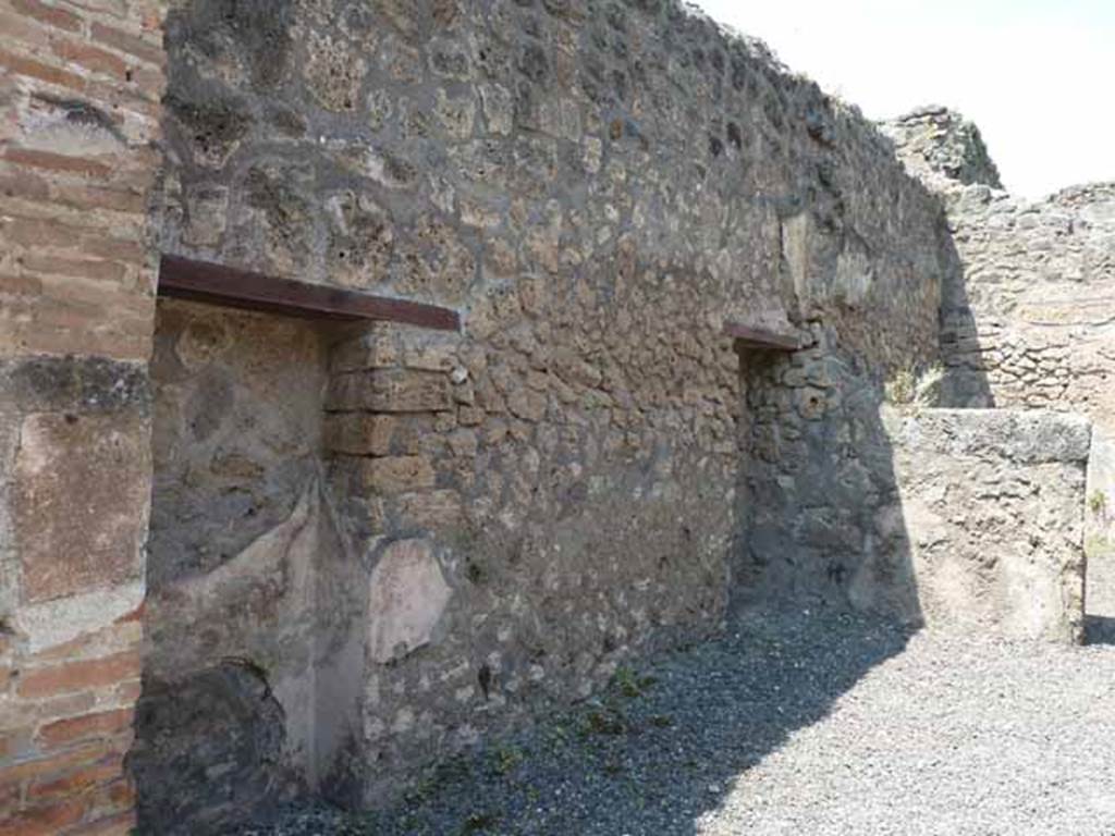 IX.1.24 Pompeii. May 2010. West wall with two blocked doorways or rectangular niches.
According to Fiorelli, this shop would have originally have belonged to the house at IX.1.22, having two blocked doorways on its left side which would have put it into communication with the shop at IX.1.23 and therefore the house at IX.1.22. At the rear of the shop was a small room, with the stairs to the upper area. 
See Fiorelli, G. (1875). Descrizione di Pompei, (p.376)
See Pappalardo, U., 2001. La Descrizione di Pompei per Giuseppe Fiorelli (1875). Napoli: Massa Editore. (p.140)