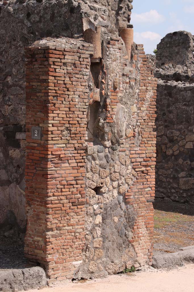 IX.2.2 Pompeii, on left. September 2021. 
Pilaster with downpipes from upper floors between IX.2.2 and IX.2.3, on right.
Photo courtesy of Klaus Heese.