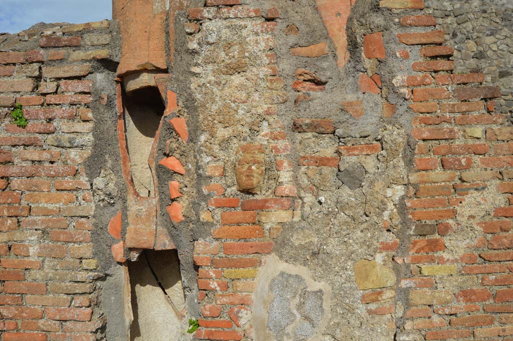 IX.2.2, on left, and IX.2.3, on right. March 2018. 
Central pilaster with downpipe. In the centre of the pilaster is a small terracotta face.
Foto Taylor Lauritsen, ERC Grant 681269 DÉCOR.