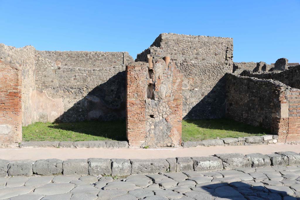 IX.2.2 Pompeii, on left, and IX.2.3, on right. December 2018. 
Looking east to entrance doorways on Via Stabiana with downpipe between. Photo courtesy of Aude Durand.