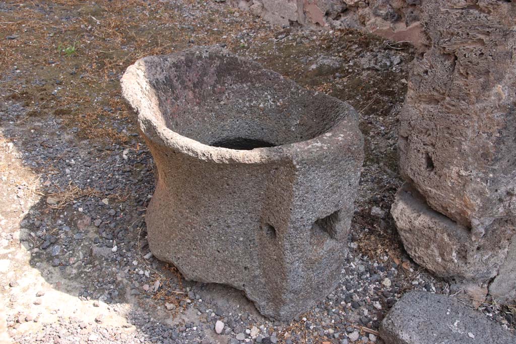 IX.2.4 Pompeii. September 2021. 
Fragment of mill (catillus) near entrance to shop, in south-west corner. Photo courtesy of Klaus Heese.