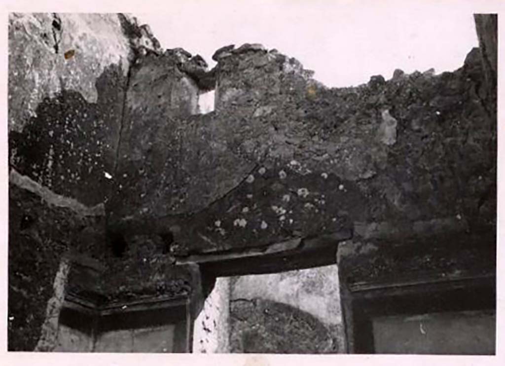 IX.2.7 Pompeii. Pre-1943. Room (i), upper south-east corner of the cubiculum. Photo by Tatiana Warscher.
See Warscher, T. Codex Topographicus Pompeianus, IX.2. (1943), Swedish Institute, Rome. (no.23.), p. 51.
According to Warscher –
“The holes for the support beams for a ceiling show that there was an upper floor, which received its light through a small window.  
A stucco strip decorated the top of the ground floor room.  
It was not possible to say what paintings decorated the centre of the side panels.”
