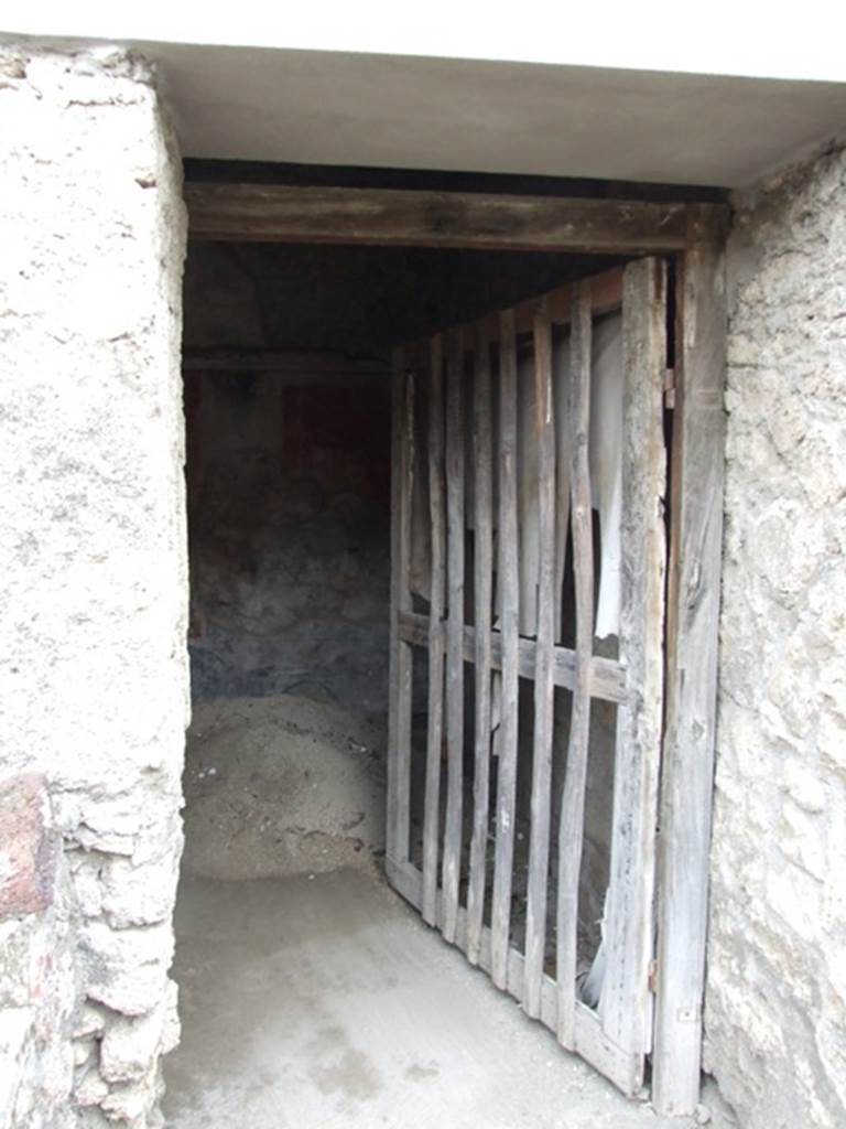 IX.2.10 Pompeii. December 2007. Doorway to cubiculum on south side of peristyle.
According to PPP, in this cubiculum the zoccolo was painted black with panels, and the middle zone of the walls would have been painted red. On the south wall, the central panel was azure blue with the painting of Galatea and Polyphemus (30 x 30).
See Bragantini, de Vos, Badoni, 1986. Pitture e Pavimenti di Pompei, Parte 3. Rome: ICCD. (p.410)
According to Fiorelli, remaining painted in this room were a group of flying Cupids and Psyches, and a figure of a naked Galatea, seen from her shoulders, embracing and joining to Polyphemus, sitting on a rock.
See Fiorelli, G, (1875). Descrizione di Pompei, (p.380).
According to Sogliano, the paintings found here would have been – Eros & Psyche (no.397) and Flying Eros & Psyche (no.398) both on a red background in the cubiculum under the south portico of garden. Galatea, (but nearly destroyed) (no.475).
See Sogliano, A., 1879. Le pitture murali campane scoverte negli anni 1867-79. Napoli: Giannini. (p.68 and p.79)
Also according to Sogliano, from the windowed cubiculum under the south portico of the garden, the following painting was seen – Female crowned figure, with a plate in her left hand, from which it seemed she was taking something with her right hand, (0.29 high red monochrome on yellow background) (no.825, p.159).  (Note: this may or may not be from this particular room).
See Sogliano, A., 1879. Le pitture murali campane scoverte negli anni 1867-79. Napoli: Giannini. (p.159)
For description of the upper zone of the wall in this cubiculum, 
See Pompejanische Kopien aus Danemark, SAP No. 24, by M.Staub Gierow. (p.231, cat 276)