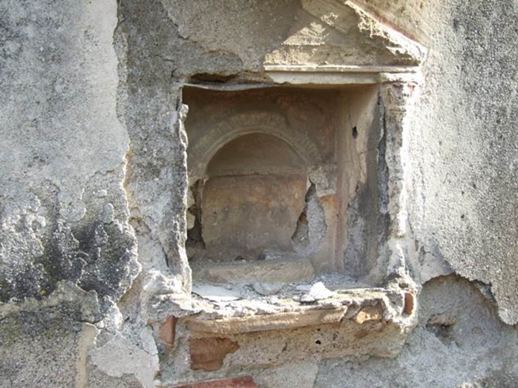 IX.2.21 Pompeii. March 2009. Room 11, south wall with aedicula shrine, and remains of stucco interior. Boyce said below the niche was a heavy ledge, richly adorned with complex triple frieze of various designs of polychrome modelled stucco. Upon it rested the bases of applied half-columns with capitals that supported the pedestal. All three cornices surrounding the tympanum were decorated with stucco friezes. The whole façade was decorated with red stripes against the white stucco background.