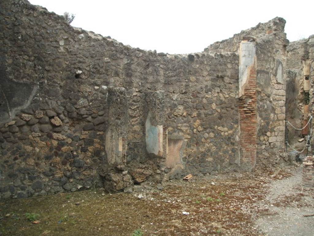 IX.2.27 Pompeii. May 2005. 
Remains of a shrine on the west wall of the peristyle. 
The doorway to the kitchen and latrine by rear entrance at IX.2.28 is on the right.