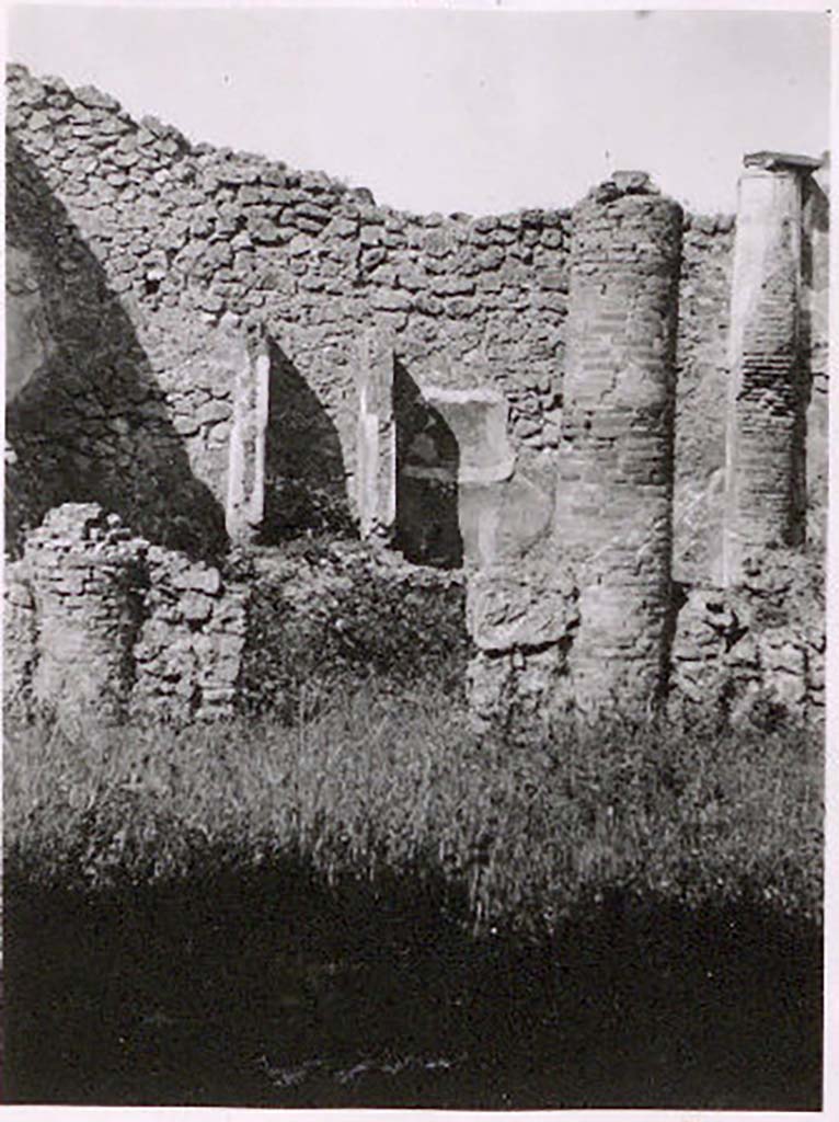 IX.2.27 Pompeii. Pre-1943. Photo by Tatiana Warscher.
According to Warscher – this house may have served as a workshop.
Against the west wall of the peristyle-like room entered directly from the street, stands a shrine; 
above a low podium (1.10 x 0.70, height 0.40) two enclosing walls (height as far as preserved 1.30) built against the wall of the room form a rectangular niche (w.0.60, d. 0.50). The floor is not preserved. The inside walls are painted with blue with red borders.
On the ground in front of the shrine stands a square masonry altar.
Giorn. Scavi, N.S, ii, 1870, p.10.
Bull. Inst., 1871, p.177.
See Warscher, T. Codex Topographicus Pompeianus, IX.2. (1943), Swedish Institute, Rome. (no.136.), p. 251.