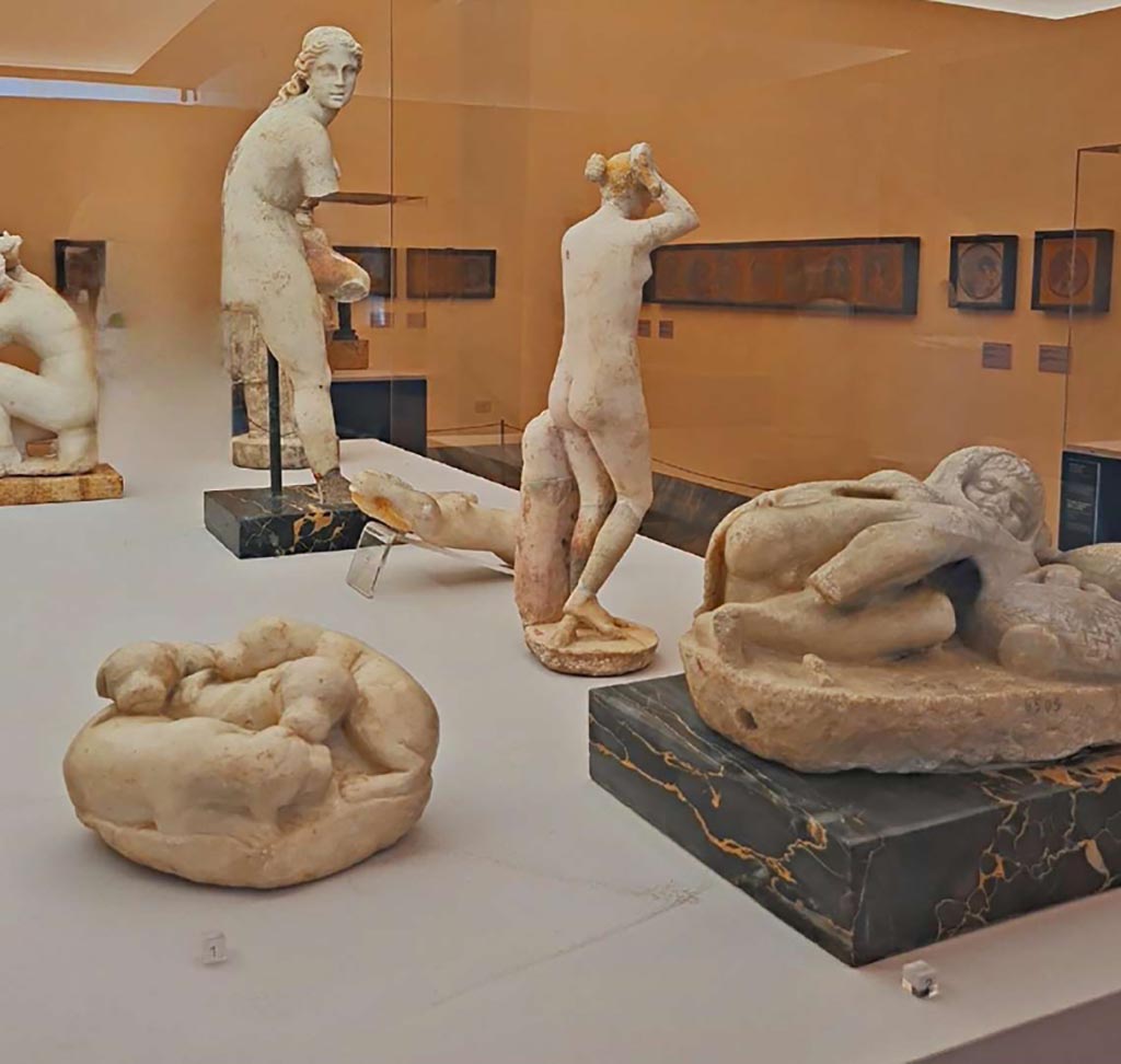 IX.3.2 Pompeii (?). October 2023. Side view of white marble statue of Venus unfastening her sandal, centre left, found 24/3/1871.
Photo courtesy of Giuseppe Ciaramella. Now in Naples Archaeological Museum, (inv. 120363).
On display in “L’altra MANN” exhibition, October 2023, at Naples Archaeological Museum.