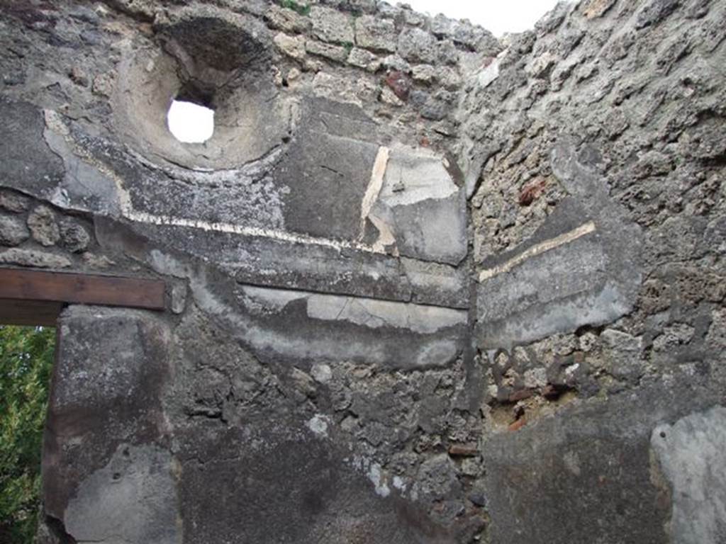 IX.3.15 Pompeii. March 2009. Room 9, north wall with door leading onto the peristyle, and small circular window above the remains of the cornice. A blocked door is in the east wall, at its north end (on right of picture).