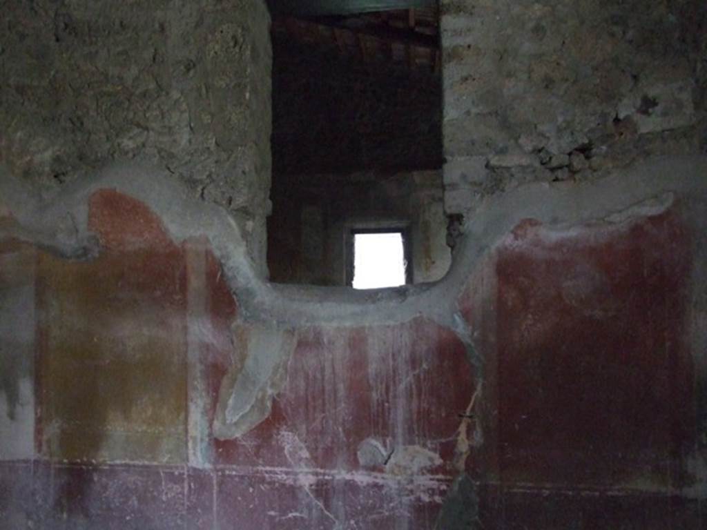 IX.3.19 Pompeii. December 2007. Room 12, north wall of triclinium, with window into oecus.
The making of the window interrupted the symmetrical structure of the IV style decoration on this wall.  This wall had a violet/purple zoccolo which was divided into panels and narrow compartments, which continued up onto the middle zone, painted with candelabra. In the middle of the wall was a red aedicula with a central painting, but only traces of the lower framework was still visible. The side panels were yellow, and at their extremity were black panels, but now totally faded and appearing white. In each of these side panels, was a medallion, also now faded, but the outline could be seen.
See Carratelli, G. P., 1990-2003. Pompei: Pitture e Mosaici: Vol. IX. Roma: Istituto della enciclopedia italiana, (p.350)