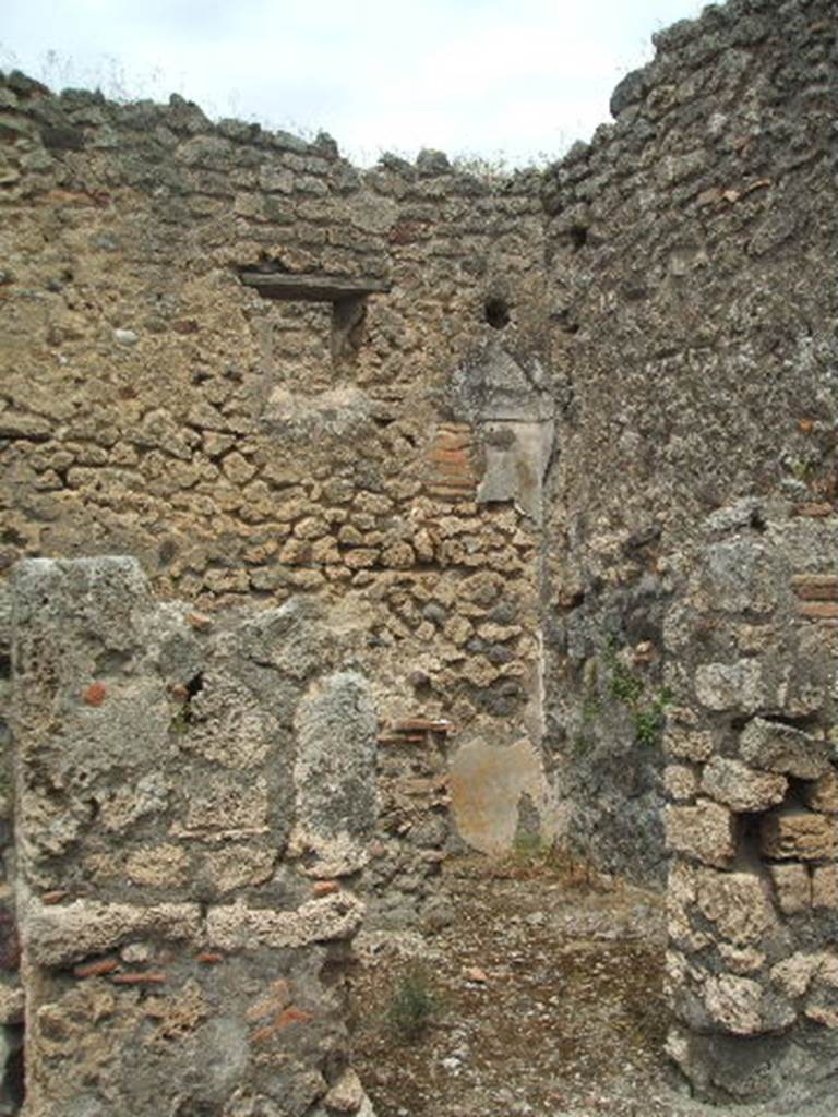 IX.3.23 Pompeii. May 2005. Doorway to kitchen and latrine, to the east of the entrance corridor. In the north wall is a window onto the small vicolo. There is a trace of a vaulted ceiling and a yellow painted zoccolo, dating from the time before the room was changed into a kitchen/latrine.