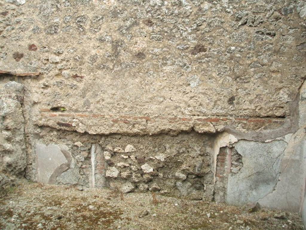 IX.3.23 Pompeii. May 2005. East wall with a blocked doorway, in room in south-east corner of atrium.  According to Fiorelli, this would have been a dormitory, with capacity for a few beds. The plinth/zoccolo was red, the middle zone of the wall was white ?. On the half-columns which decorated the doorposts were the remains of painted faux marble.
See also Bragantini, de Vos, Badoni, 1986. Pitture e Pavimenti di Pompei, Parte 3. Rome: ICCD. (p.450)