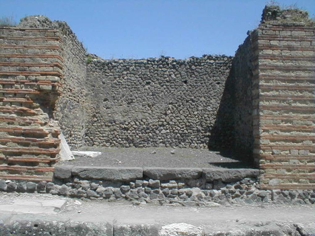 IX.4.2 Pompeii. May 2005. Looking east towards entrance on Via Stabiana.
According to Maiuri, three of the shops on the corner of this insula, appear to have had an elevated threshold of at least 0.80m above the floor of the sidewalk and what should have been the original threshold. They clearly distinguish the brickwork/masonry of the above elevation from the original floor of the threshold. In the third taberna (from the corner of the quadrivium) IX.4.3, only one block of the threshold appears located in its place.
See Maiuri, A, (2002): L’ultima fase edilizia di Pompei, Arte Tipografica, Naples, (p.75, note 3).