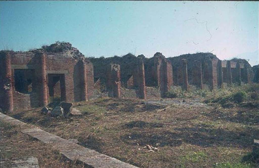 IX.4.18 Pompeii. East side of baths, looking south-east. 
Photographed 1970-79 by Günther Einhorn, picture courtesy of his son Ralf Einhorn.
The doorway on the left would have led to the apodyterium (changing room) “i”.
In the centre would have been the three windows of the frigidarium (cold) “p”.
On the right are the three large windows of the tepidarium (warm) “q”.
The caldarium (hot room) “s” would be the room with three square windows, on the right.