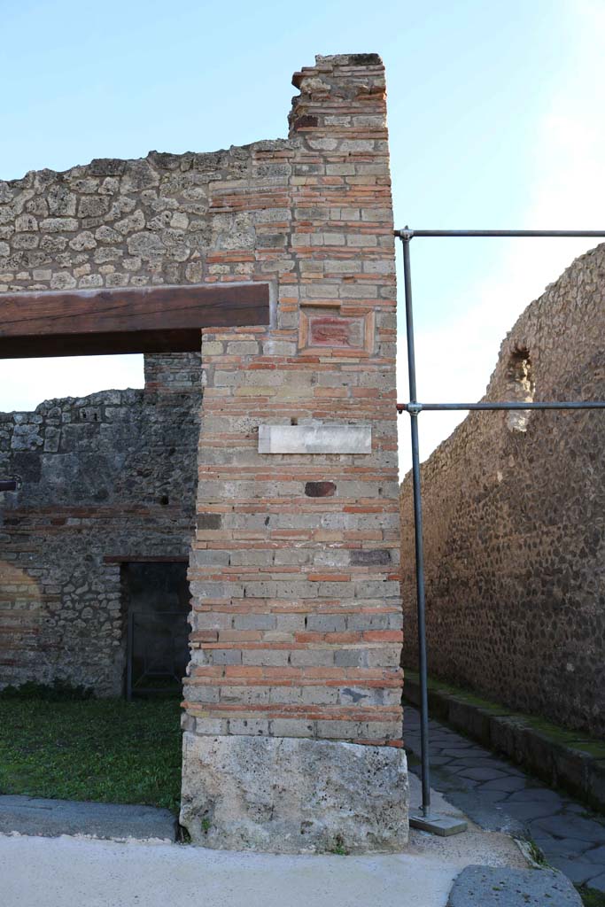 IX.5.1 Pompeii. December 2018. 
Pilaster on wall on west side of entrance, with terracotta plaque of phallus. Photo courtesy of Aude Durand.