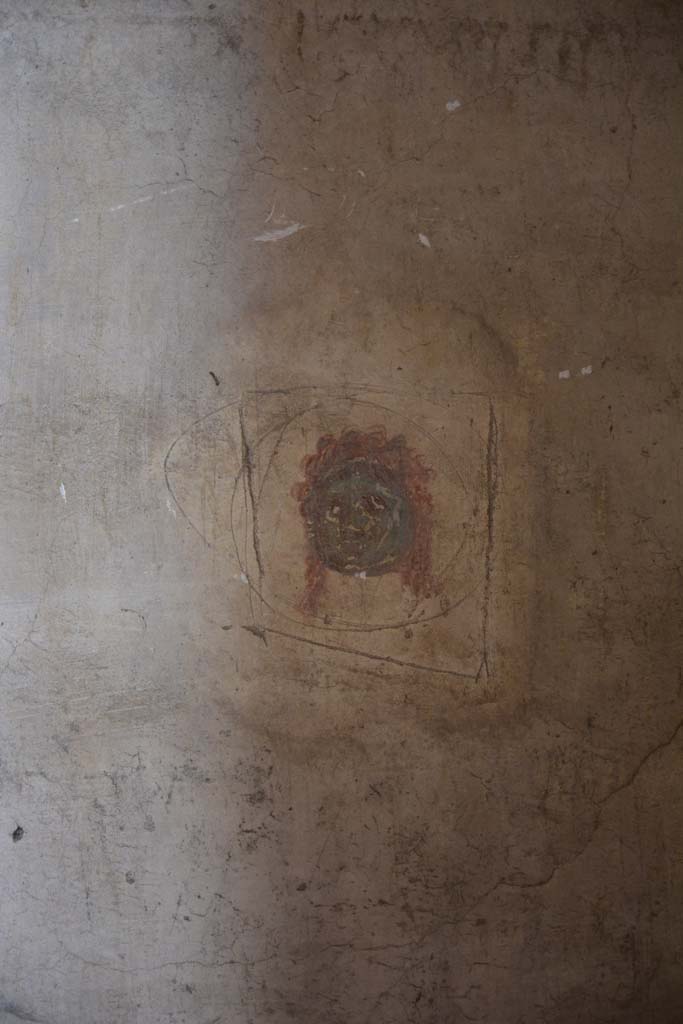 IX.5.6 Pompeii. May 2017. 
Room k’, east wall at north end.
According to PPM –
This was a painted vignette of a green female mask on a white background, with eyes, nose, mouth and hair in red.
The encircling incision surrounding it, was a sign of an attempted robbery.
Foto Christian Beck, ERC Grant 681269 DÉCOR.