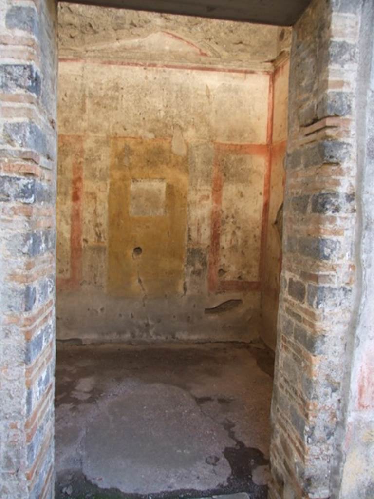 IX.5.11 Pompeii. December 2007. Doorway to room 7, looking west.
According to BdI, on the walls of this room traces of burning could have been seen. 
In the centre of the west, north and south walls were paintings, on a yellow panel.
See BdI, 1879, (p.203-205,  nos: 63-84 in “g”).
According to Fiorelli, other than the usual flying Cupids, in the frieze on the west wall were two small female figures (caryatids) crowned with foliage and with green robes.
See Notizie degli Scavi di Antichitŕ, 1877, (p.249-50)