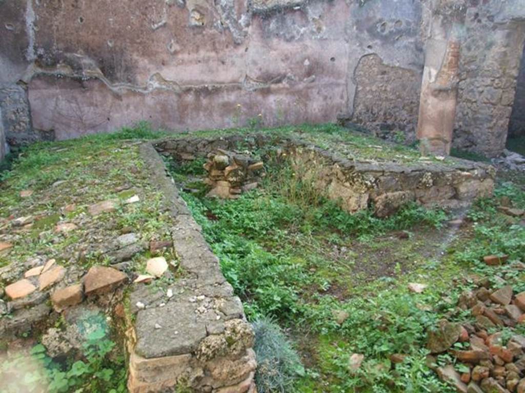 IX.5.11 Pompeii. December 2007. Room 15, looking south-west across triclinium in garden area.  According to Soprano –  “Ubicazione: giardino. L. medius, m.410; l. imus, m.3.86; l. summus, m.3.12; diametro della mensa, m.0.90; lunghezza della panca, m.1.05; larghezza della panca, m.0.55.
Bibliog. Thedenat, op. c. p.84, “Bull. Inst”. 1874, p.195, Viola, op. c. p.29; Mau-Kelsey, p.258.
Occupa tutta l’area di un piccolo giardino con, su due lati, un portichetto composto di cinque colonne, tre sul lato meridionale e due sul lato occidentale, e con gli intercolunni chiusi da un basso pluteo.
Nessuno dei tre letti, a piano inclinato, era addossato a muri.  La mensa, circolare, ha intorno alla base sei nicchiette absidate. Sul  prolungamento del l. imus v’era una piccola panca rettangolare che era poco piu basso dei tre letti; serviva per sgabello ai bambini che dovevano consumare i pasti stando seduti e non sdraiati. Sotto questo podio c’era una nicchietta rettangolare, e a destra una vaschetta quadrata formata con grosse pietra vesuviane. Davanti al l. summus, infine, era situata una base a sezione quadrata, Le pareti del giardino sono rivestite d’intonaco rosso, e lungo le pareti verticali del l. imus si nota qualche traccia di intonaco d’incerta colore.
See Soprano, P. (1950). I triclini all’aperto di Pompei. (In Pompeiana, raccolta di studi per il secondo centenario degli scavi di Pompei. Napoli, Gaetano Macchiaroli, Editore, P. 302-3, no.19).