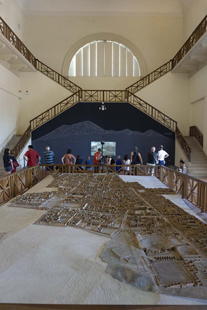 Cork model on display on Naples Archaeological Museum. July 2017.
Looking north from Gladiators Barracks and Theatres at VIII.7 on Via Stabiana, lower right.
Foto Annette Haug, ERC Grant 681269 DÉCOR.
This model in the Naples Archaeological Museum, made of wood, cork and paper, by Felice Padiglione, is scaled at 1/100, and shows the excavations up until the end of 1879.
Many models of the city were produced, including one on display in an exhibition in VIII.2.14/16 in 2018.
That model featured the houses on the western side of VIII.2, that is VIII.2.1/3 the Houses of Championnet, VIII.2.14/16, VIII.2.17/21 the Sarno Baths, and the next few properties on the southern slope.
According to the Archaeological Park of Pompeii display notice in VIII.2.14/16 - 
“The cork model was begun in 1865 by Giovanni Padiglione, one of several models predating the great model of the entire city now in Naples Archaeological Museum. 
It was created over the course of several stages, following the advance of archaeological discoveries, as demonstrated by the Courtyard of the Moray Eels, excavated at the end of the nineteenth century, and the lower floors of the houses which were investigated in the 1930’s.
In addition, the wall and floor decorations, painted on paper, do not correspond with those that were originally present; most probably it was decided to substitute them with those of a more profound impact from other houses, for educational purposes.”